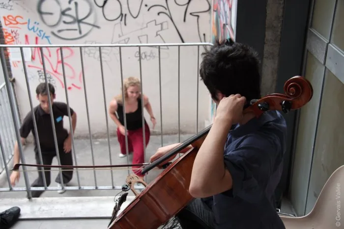 Une danseuse en mouvement sur une place, entourée de passants